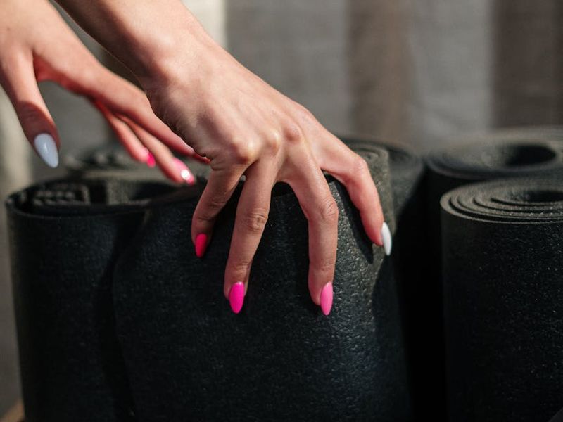 Detailed close-up of a yoga mat and hands in motion.