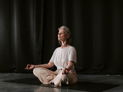 Hands folded in a mudra position on knees.